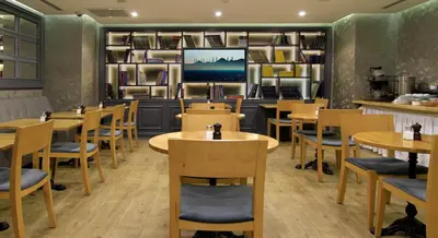 a restaurant with tables and chairs and a tv at Aston Hotel Taksim in Istanbul