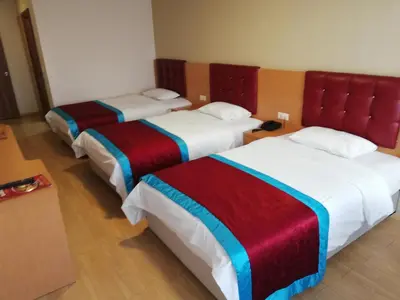 a hotel room with three beds with colorful blankets at BURSA ŞAHiN HOTEL in Bursa