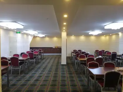 an empty room with tables and chairs in it at BURSA ŞAHiN HOTEL in Bursa