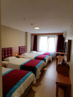a hotel room with three beds in a room at BURSA ŞAHiN HOTEL in Bursa