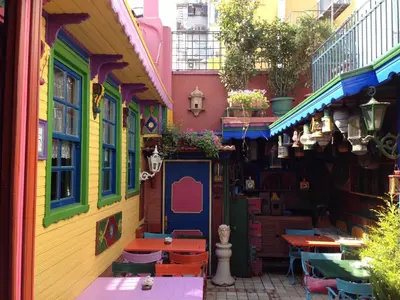 a street with colorful buildings with tables and chairs at Kybele Hotel in Istanbul