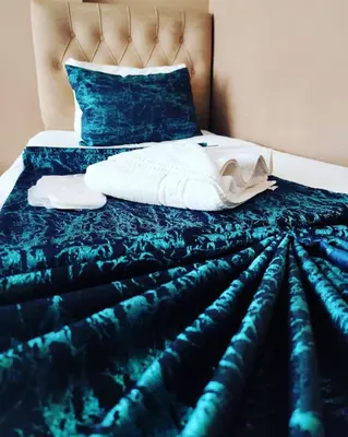 a bedroom with a bed with a blue comforter at Hotel Estambul in Istanbul