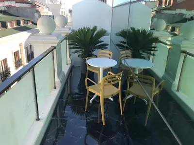 a balcony with tables and chairs on a building at The Meretto Hotel Istanbul Old City in Istanbul
