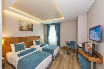 a hotel room with two beds and a desk at The Meretto Hotel Istanbul Old City in Istanbul