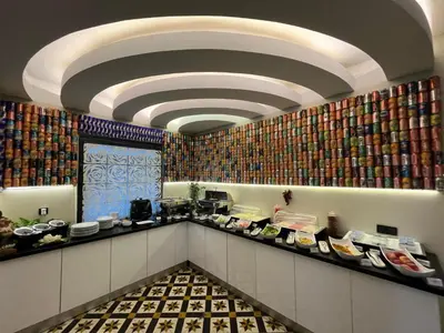 a restaurant with a counter with books on the wall at Tempo Hotel Caglayan in Istanbul