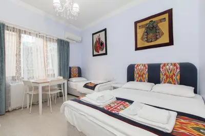 a hotel room with two beds and a table at SUFI APART Otel in Istanbul