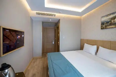 a hotel room with a bed and a tv at Meretto Hotel LALELİ in Istanbul