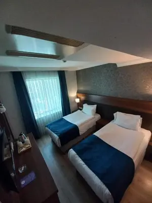 a hotel room with two beds and a table at Rhiss Hotel Bostanci in Istanbul