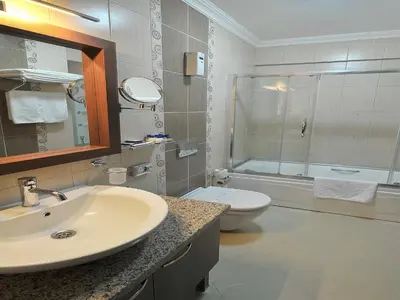 a white bathroom with a sink and a toilet at Rhiss Hotel Bostanci in Istanbul