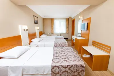 a hotel room with four beds and a television at Baron Hotel & Spa in Istanbul