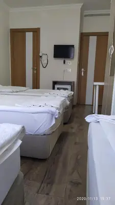 a room with three beds and a flat screen tv at Marpalace Hotel in Istanbul