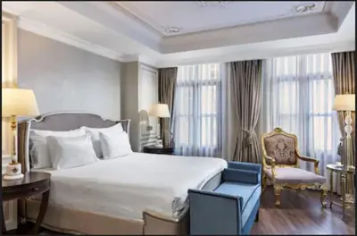 a bedroom with a large bed and a blue chair at Rixos Pera Istanbul in Istanbul