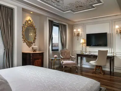 a bedroom with a bed and a desk and a computer at Rixos Pera Istanbul in Istanbul