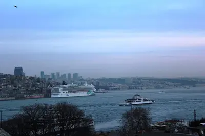 two boats on the river with a city in the background at Septimum in Istanbul