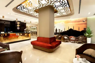 a lobby with a red bench and chairs in a building at Sorriso Hotel in Istanbul