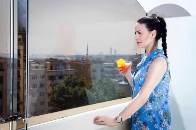 a woman holding a cocktail in front of a window at Sorriso Hotel in Istanbul