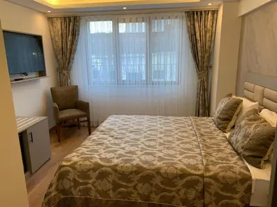 a bedroom with a bed and a chair and a window at Regency World Hotel in Istanbul