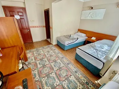 a small room with two beds and a rug at Kadikoy Kervansaray Hotel in Istanbul