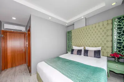 a bedroom with a bed and a green headboard at Green Garden Hotel - Bahçelievler in Istanbul
