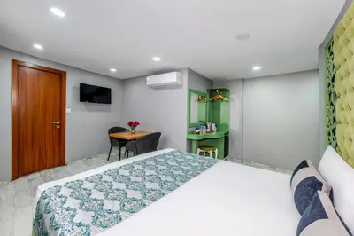 a bedroom with a large bed and a table at Green Garden Hotel - Bahçelievler in Istanbul