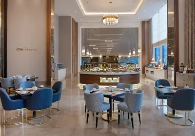 a restaurant with tables and chairs and a counter at Elite World Grand Istanbul Küçükyalı in Istanbul