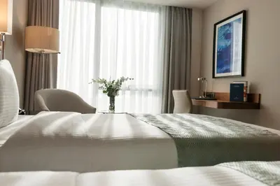 a hotel room with a bed and a vase of flowers at Elite World Grand Istanbul Küçükyalı in Istanbul