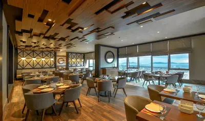 a restaurant with tables and chairs and windows at Elite World Grand Istanbul Küçükyalı in Istanbul