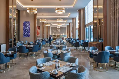 a dining room with tables and chairs and chandeliers at Elite World Grand Istanbul Küçükyalı in Istanbul