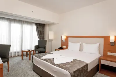 a hotel room with a bed and a chair at Mercia Hotels & Resorts in Buyukcekmece
