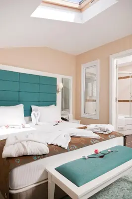 a bedroom with two beds with white sheets and a blue headboard at Mercia Hotels & Resorts in Buyukcekmece