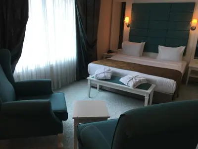a hotel room with two beds and two chairs at Mercia Hotels & Resorts in Buyukcekmece