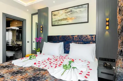 a bedroom with a bed with white sheets and red flowers at The Magnaura Palace Hotel in Istanbul