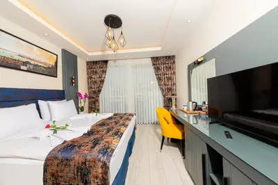 a hotel room with a bed and a flat screen tv at The Magnaura Palace Hotel in Istanbul