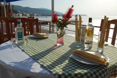 a table with a green and white checkered table cloth with bottles and glasses at Grand Koru Hotel Beach in Yalova