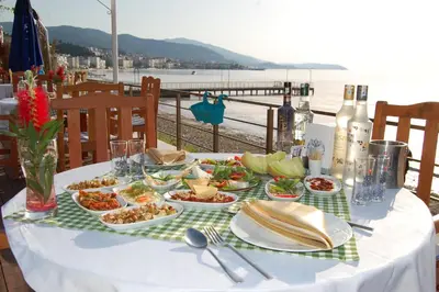 a table with plates of food and a view of the ocean at Grand Koru Hotel Beach in Yalova
