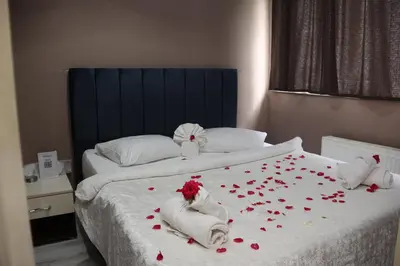 a bedroom with two beds with red rose petals on the bed at Grand Koru Hotel Beach in Yalova