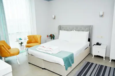 a white bedroom with a bed and a chair at Nar Palace in Istanbul