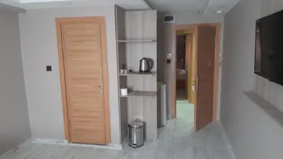 a hallway with a wooden door and a room with a television at Moon Suit Hotel in Istanbul