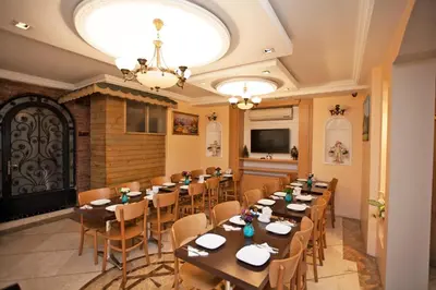 a restaurant with wooden tables and chairs and a chandelier at Hotel Bulvar Istanbul in Istanbul