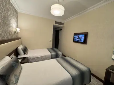 a hotel room with two beds and a tv at Hotel Bulvar Istanbul in Istanbul