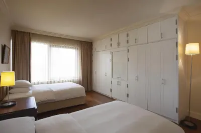 a bedroom with two beds and a large closet at Grand Hyatt Istanbul in Istanbul