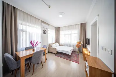 a living room with a table and chairs and a couch at Feyza Apart in Istanbul