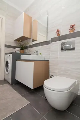 a bathroom with a toilet and a sink and a washing machine at Zin D Home Otel Alemdağ in Istanbul