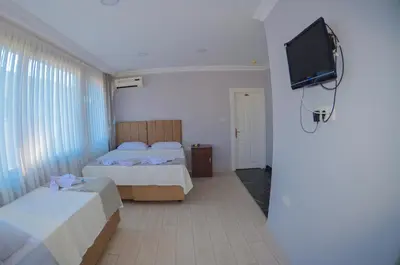a bedroom with two beds and a flat screen tv at Hotel Yasmin in Istanbul