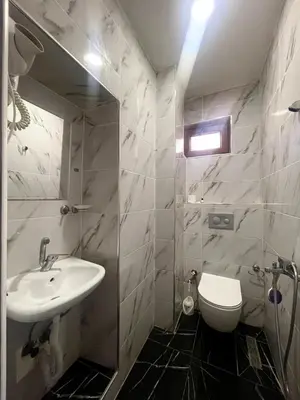 a white bathroom with a sink and a toilet at Hotel Yasmin in Istanbul