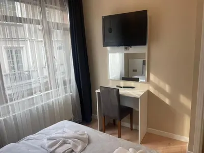a bedroom with a desk and a television on the wall at Blue Mosque Apart in Istanbul