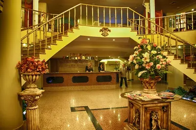 a lobby with a staircase and two vases of flowers at Hotel Eken Prestige in Bandırma