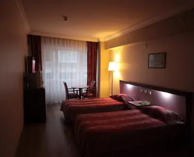 a hotel room with two beds and a table at Hotel Eken Prestige in Bandırma