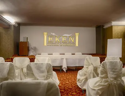 a room with white chairs and tables and a sign at Hotel Eken Prestige in Bandırma
