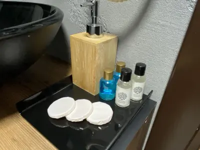 a black tray with three bottles of soap and a sink at Insta Hotel Karakoy in Istanbul
